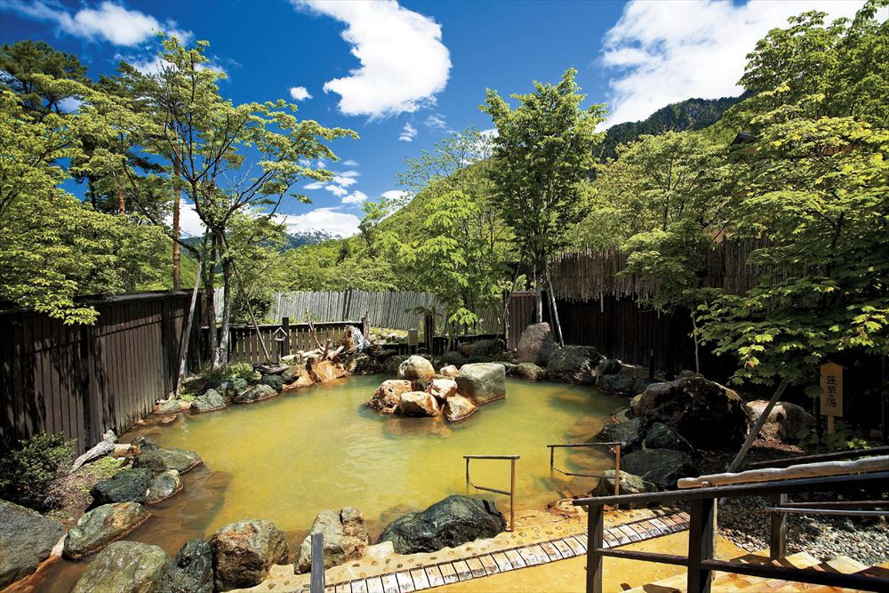 Takumi no Yado Miyama Ouan_The open-air bath in the large common bathing area is fed by free-flowing hot spring waters direct from the source. Floating in these soft waters with a magnificent view of the Northern Alps is a moment of true bliss.